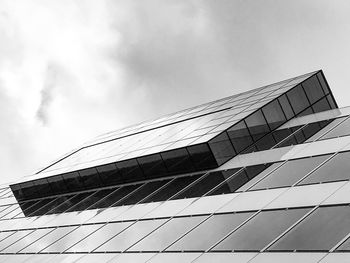 Low angle view of modern building against cloudy sky