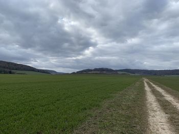 Road amidst field against sky in eichsfeld, thuringia, germany