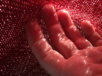 Cropped hand of child on textile in sunny day