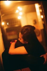Shadow of woman sitting in illuminated room