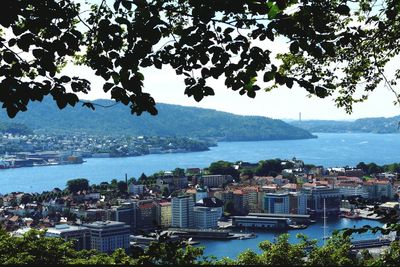 High angle view of city by sea against sky