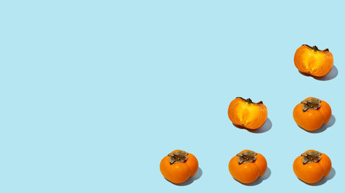 Persimmon fruit with leaves on blue background. healthy eating and food concept. flat lay