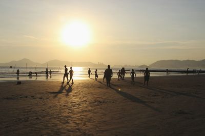 People on beach at sunset