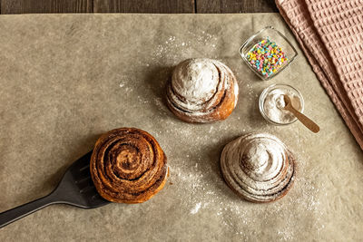 Freshly baked cinnamon pastry buns, sprinkled with powdered sugar and pastry topping.