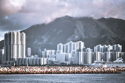 Buildings in city against cloudy sky