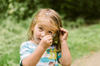 Close-up portrait of girl holding hair clip