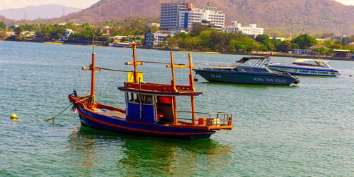 Boat moored on sea by city