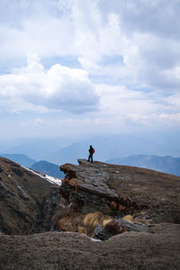 People on rock against sky