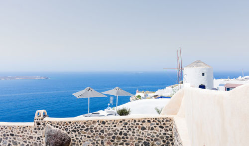 Amazing panoramic view of some white houses of the village of touristic oia in santorini island in aegean sea. the windmill is at the top of the village and the sea at the background. horizon