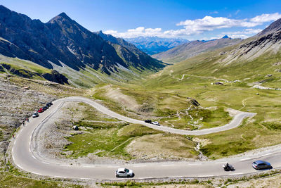 Cars on winding road against mountain range