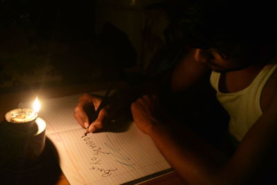 Close-up of teenage boy writing in book