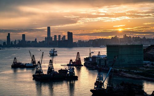 Scenic view of sea and buildings against sky during sunset, kowloon, hong kong