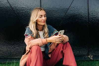 Young attractive woman is using mobile phone for online messaging. person