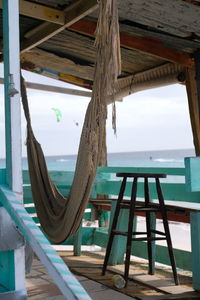 Deck chairs on beach against sky