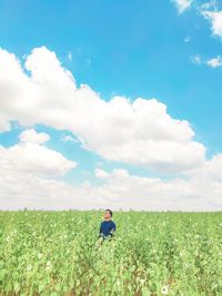 Man standing by plants against sky