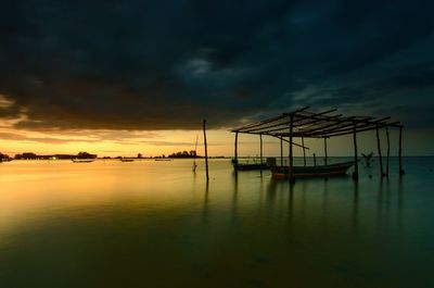 Silhouette sailboats in sea against sky during sunset