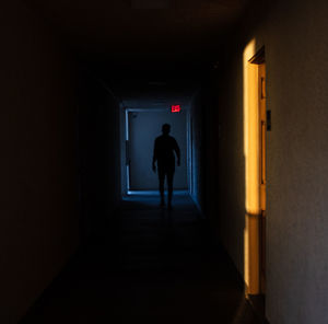 Silhouette woman walking in tunnel