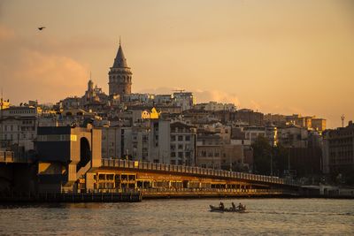 Bridge over river against buildings in city