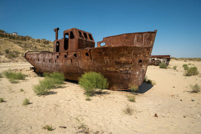 Old ruins on beach against clear blue sky