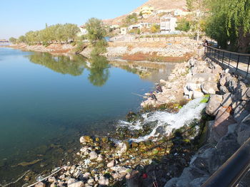 High angle view of lake by buildings in city