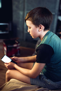 Boy using mobile phone at home