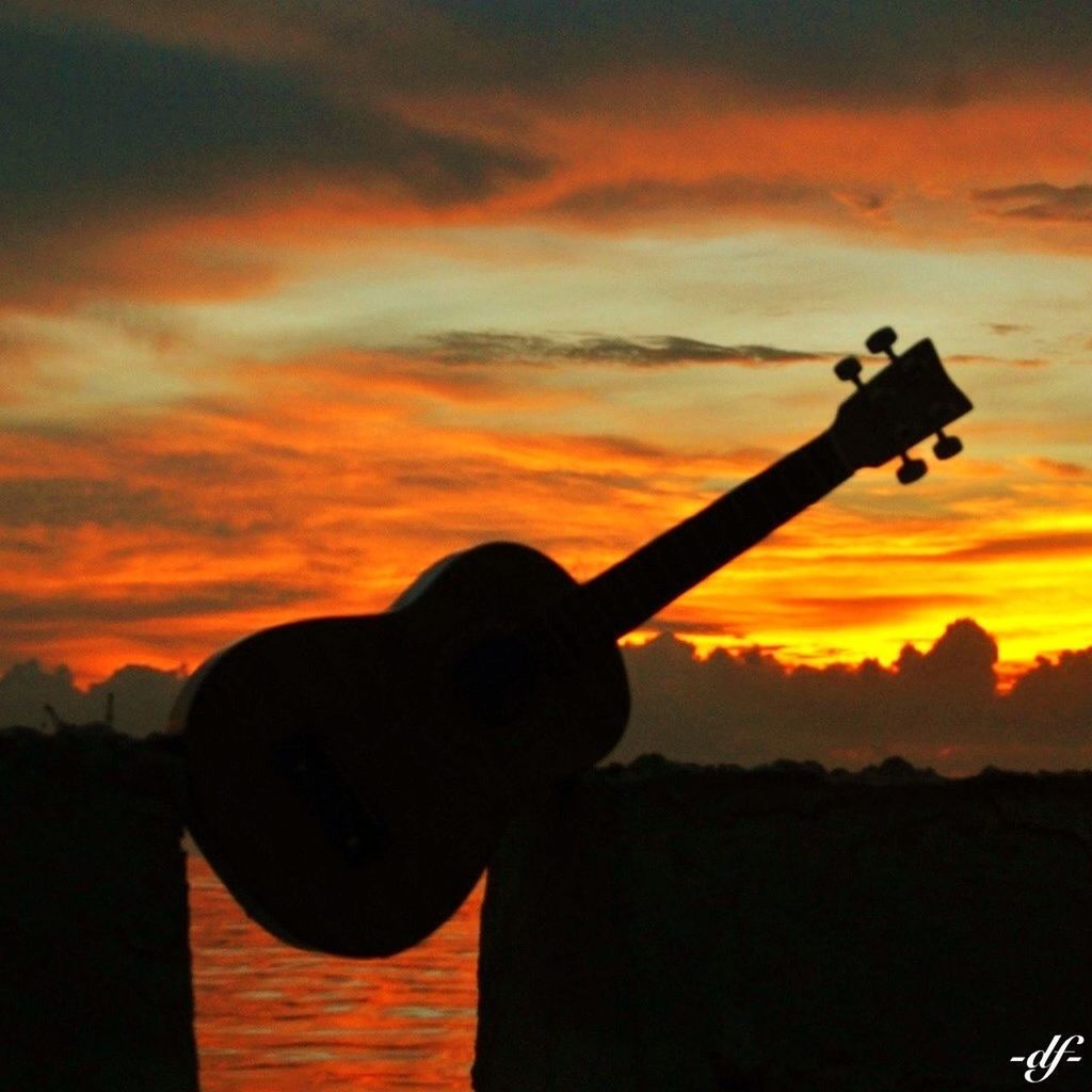 sunset, silhouette, orange color, sky, lifestyles, leisure activity, holding, cloud - sky, photography themes, technology, photographing, men, camera - photographic equipment, dramatic sky, standing, hobbies, beauty in nature, three quarter length