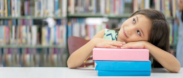 Portrait of boy sitting on book