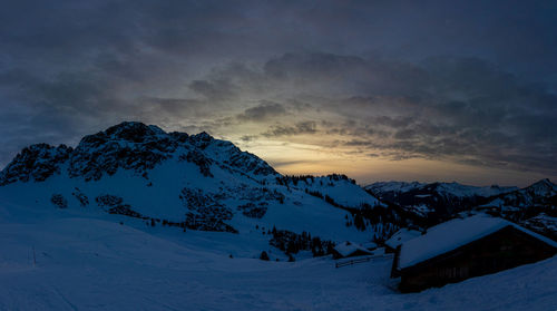 Scenic view of snow covered mountains against sky during sunset