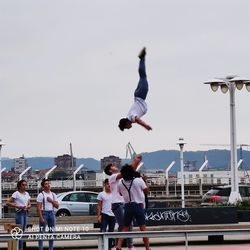 Rear view of people on boat against sky