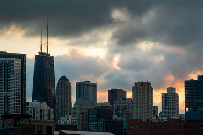 Modern buildings against sky during sunset