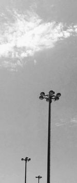 Low angle view of bird perching on statue of street light