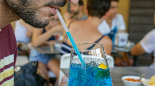 Close-up of man holding drink on table