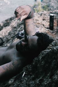 Low section of man sitting on rock