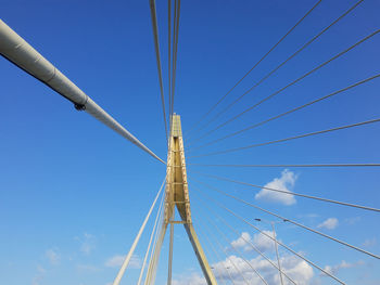 Low angle view of suspension bridge against clear blue sky