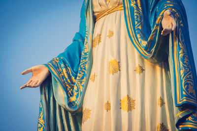 Close-up of woman standing against blue background