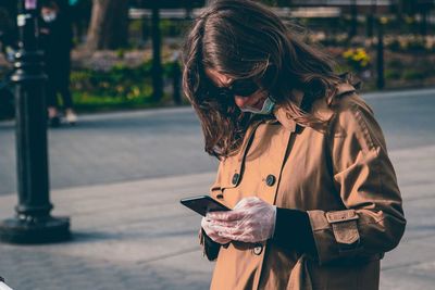 Man using mobile phone while standing on street