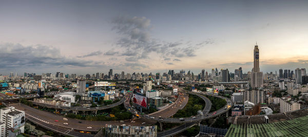 High angle view of city buildings against cloudy sky