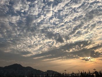 Silhouette of city against sky during sunset