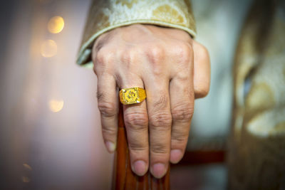 Close-up of man wearing gold ring