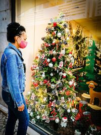 Woman standing by christmas tree