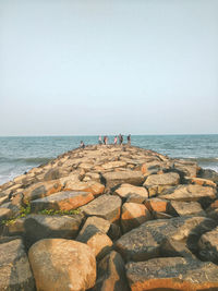 Rocks on beach against clear sky