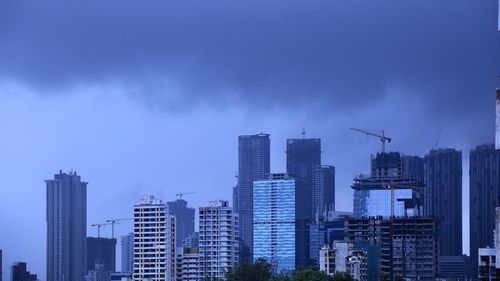 Modern buildings in city against blue sky