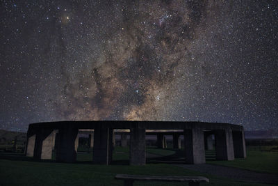 Built structure on field against sky at night