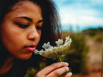 Close-up portrait of woman holding flower