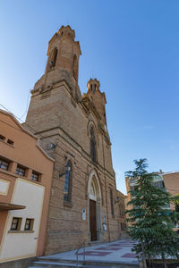 Low angle view of historic building against clear blue sky