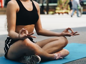 Low section of young woman doing yoga