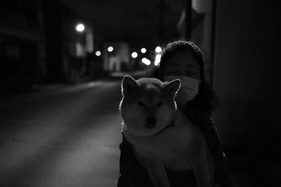 Portrait of man with dog at night