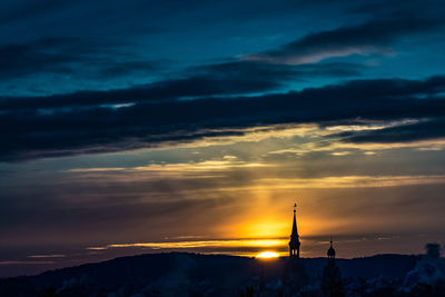 Silhouette buildings against sky during sunset