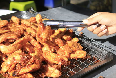 Close-up of person preparing food on barbecue grill