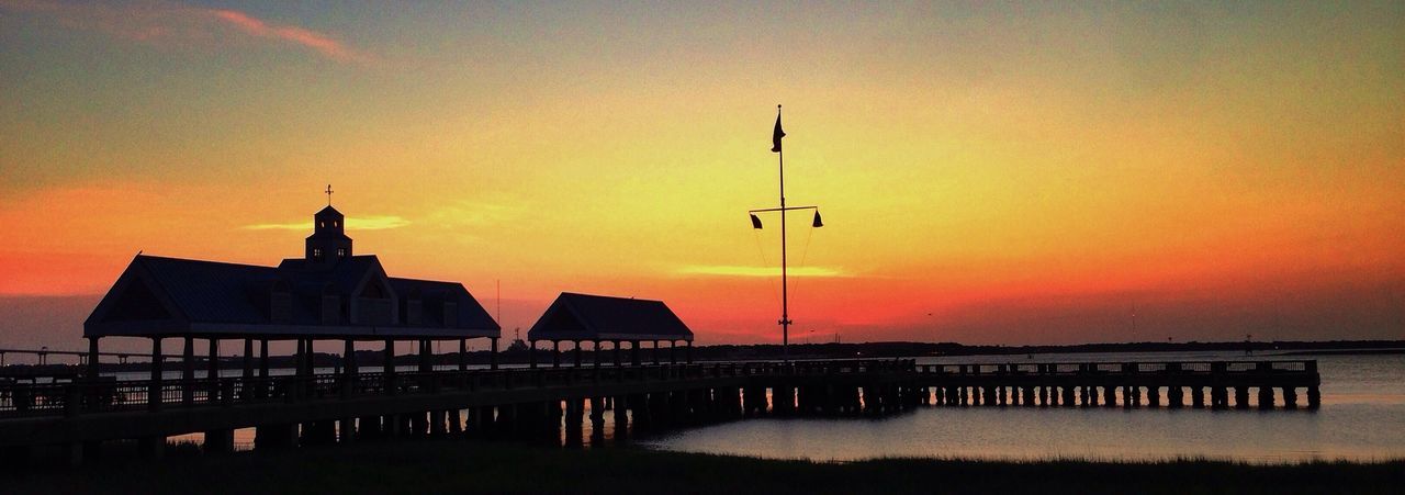 sunset, orange color, built structure, architecture, sky, scenics, tranquility, beauty in nature, silhouette, tranquil scene, idyllic, building exterior, nature, water, sun, cloud - sky, railing, outdoors, dusk, no people